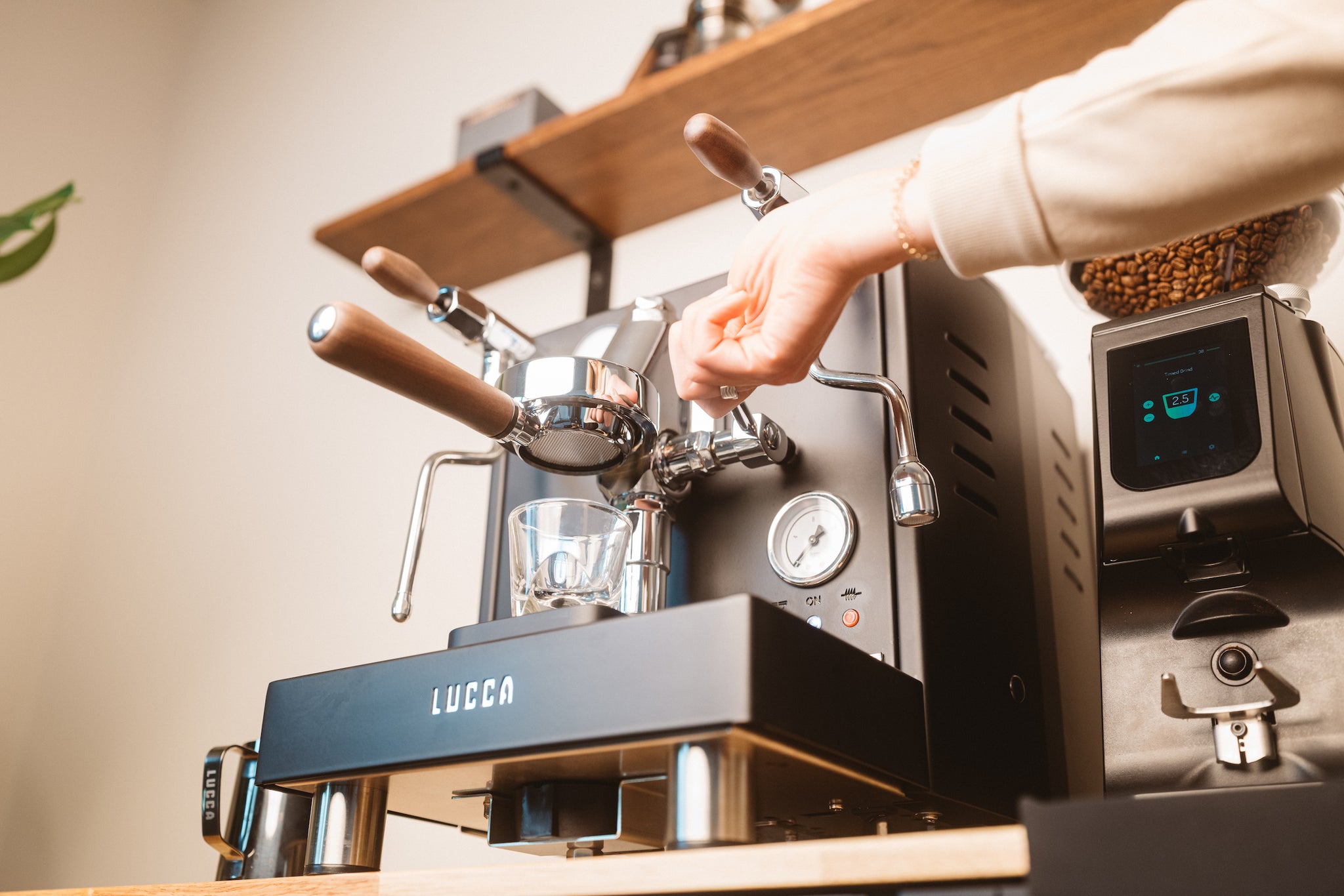 Lifting brew lever on the LUCCA M58 espresso machine with LUCCA Atom 75 espresso grinder