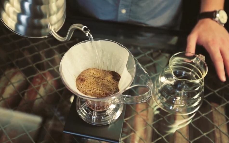 Pour over coffee brewing with a paper filter and hot water pouring into the filter