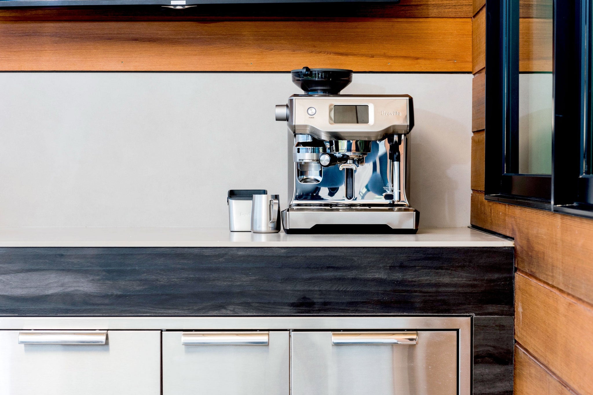 Breville espresso machine on a kitchen counter with a top grinder and portafilter