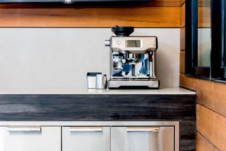 Breville espresso machine on a kitchen counter with a top grinder and portafilter
