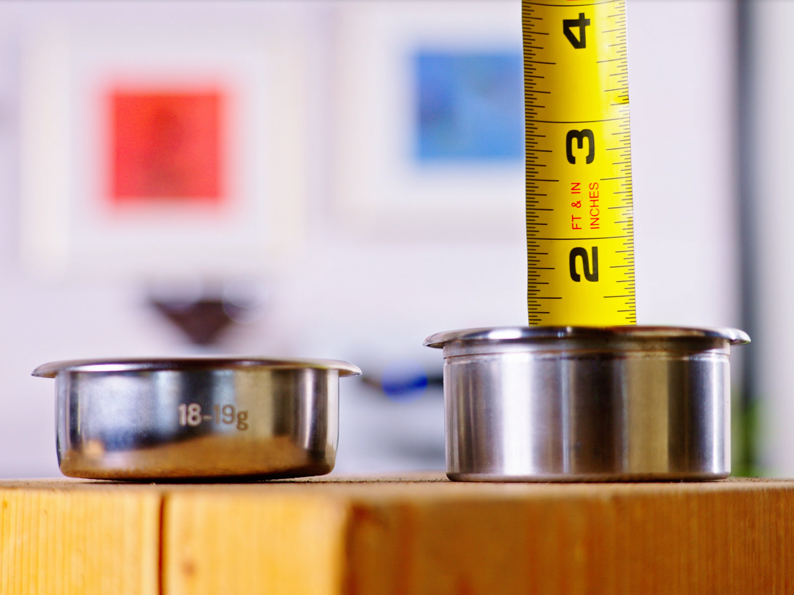 Espresso machine with two portafilters and a yellow measuring tape showing dose size