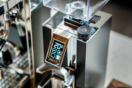 Close up of a shiny espresso grinder showing a large dial and blue digital readout for grind settings.