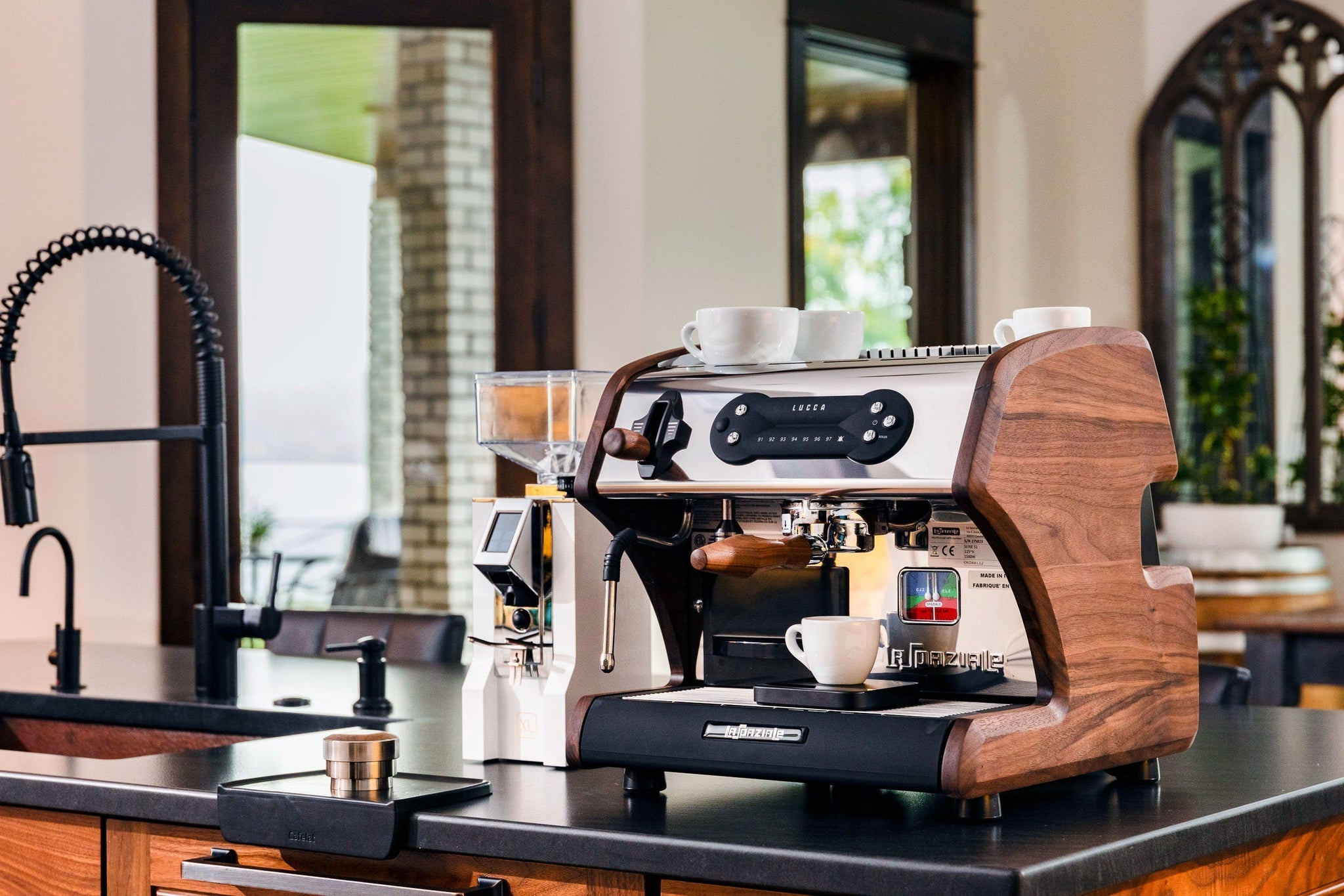 LUCCA A53 Mini espresso machine on a kitchen counter with white cups on top.