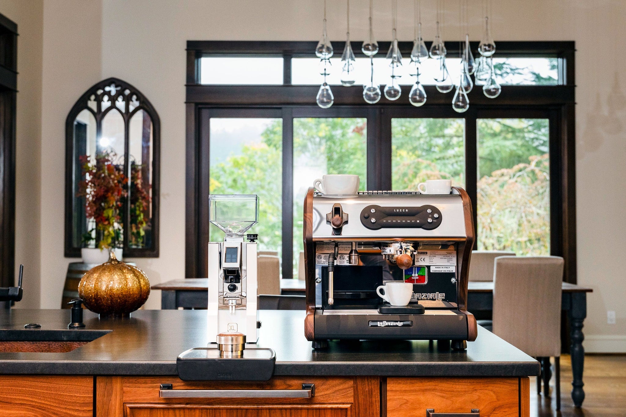 LUCCA espresso machine on a kitchen island with two white cups on top and a coffee grinder beside it