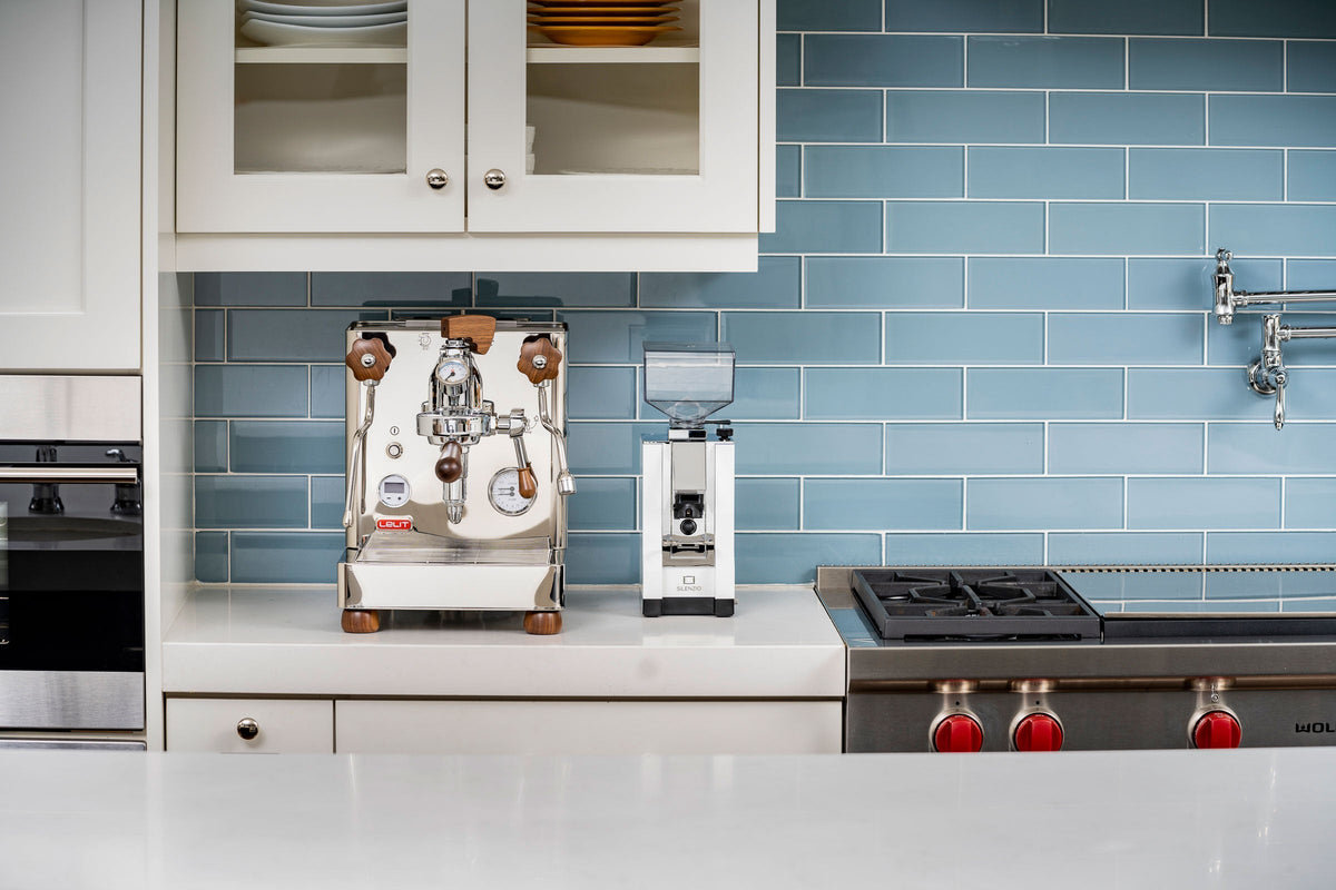 Lelit Bianca V3 and LUCCA A53 Pro espresso machines on a kitchen counter with a blue tiled backdrop
