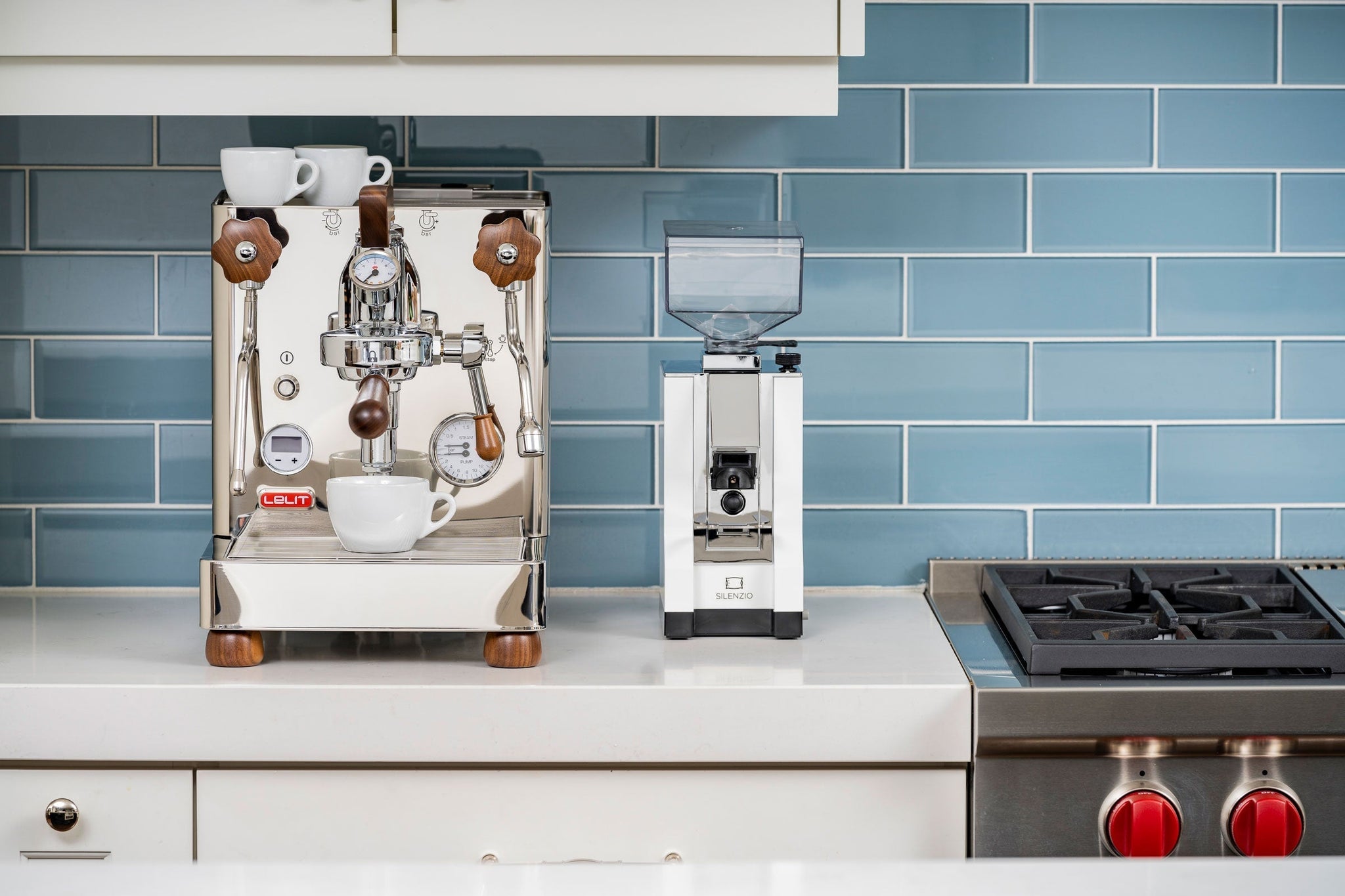 Lelit Bianca V3 chrome espresso machine with two white cups on top against blue tiled backsplash