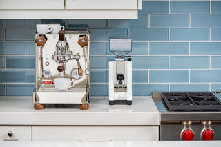 Lelit Bianca V3 chrome espresso machine with two white cups on top against blue tiled backsplash