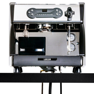 Front view of a LUCCA espresso machine with portafilter, steam wand, and two gauges on a chrome panel.