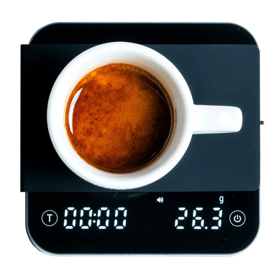 Top view of a white ceramic espresso cup on a digital kitchen scale