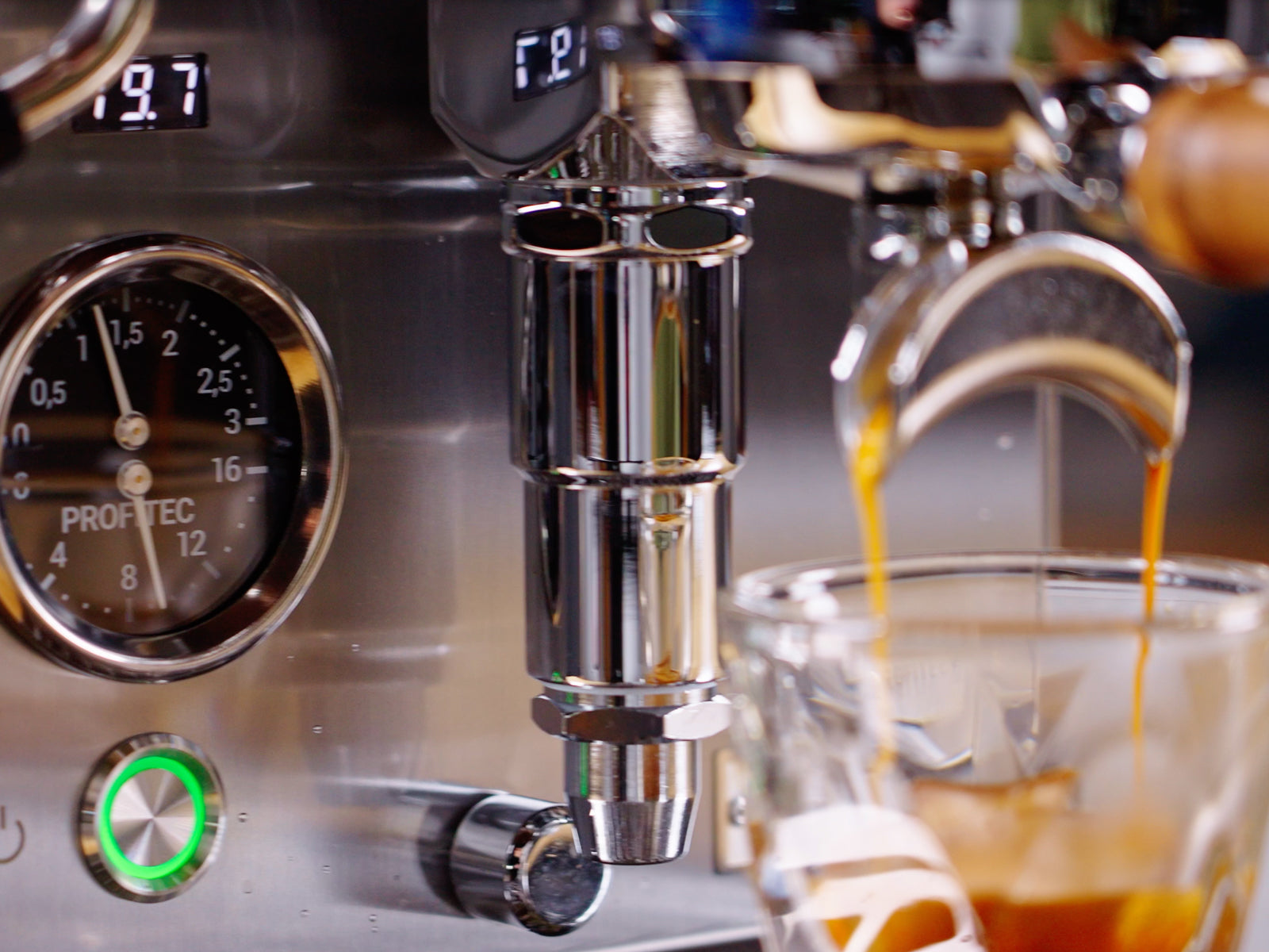 close up of an espresso extraction with the pressure gauge reading 9 bar in the background lifestyle by clive coffee