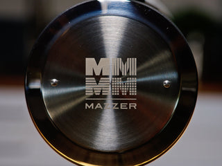 Close up of a polished Mazzer Mini espresso grinder lid with a brushed metal finish.