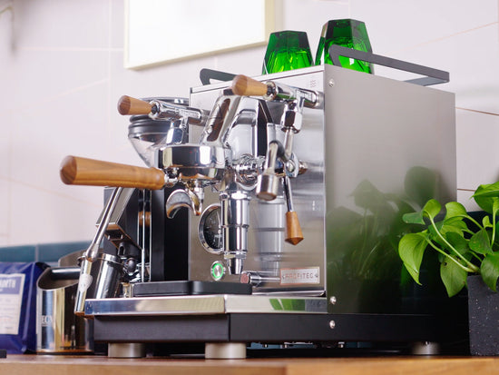 Profitec Jump espresso machine in stainless steel with two green cups on top in a modern setup.