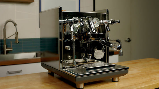 ECM Synchronika II chrome espresso machine with dual group heads and gauges on a kitchen counter