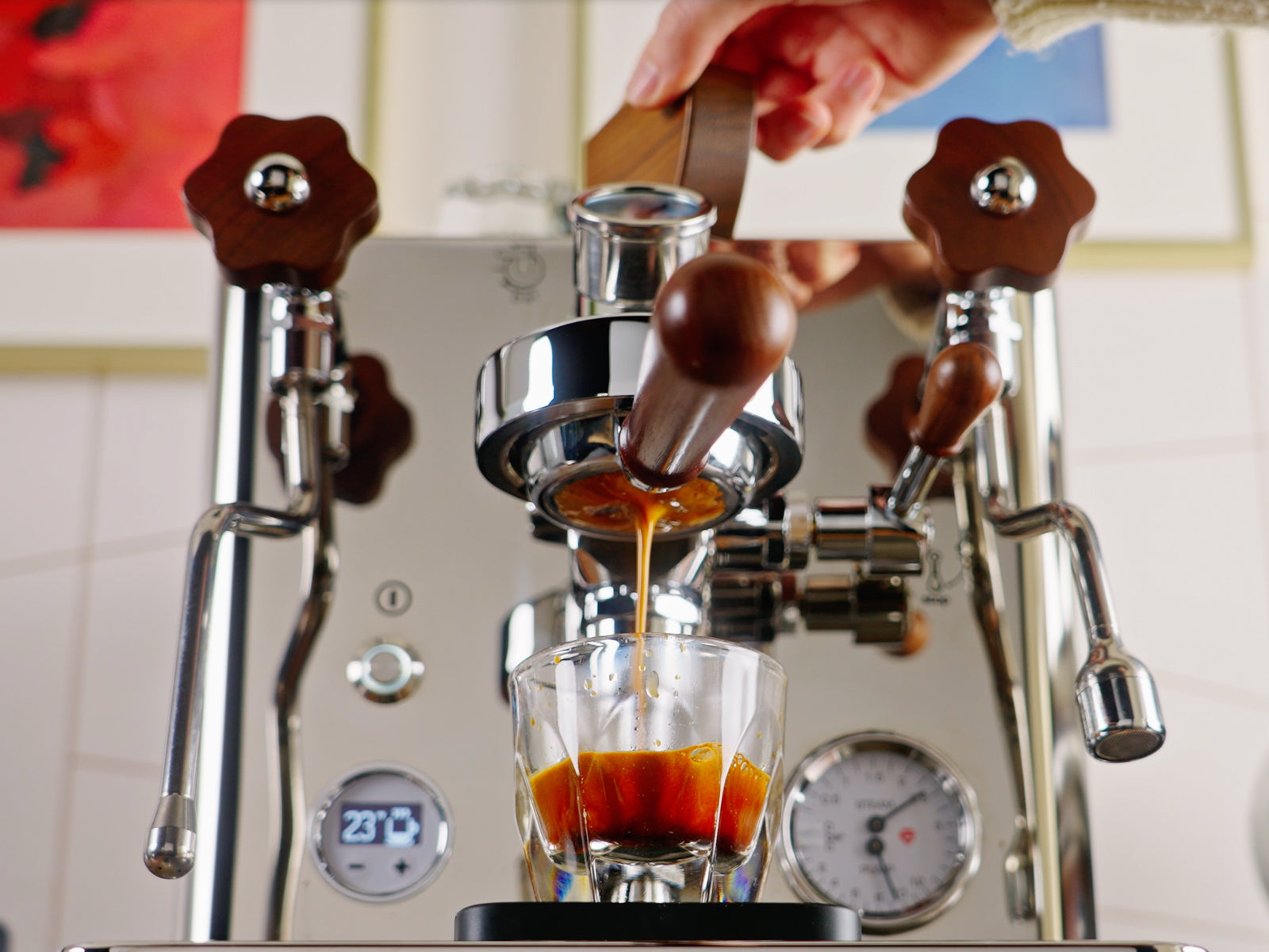 Espresso machine dispensing coffee into a glass with crema