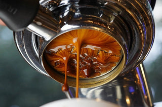 Close up of espresso extraction with crema swirling from the portafilter