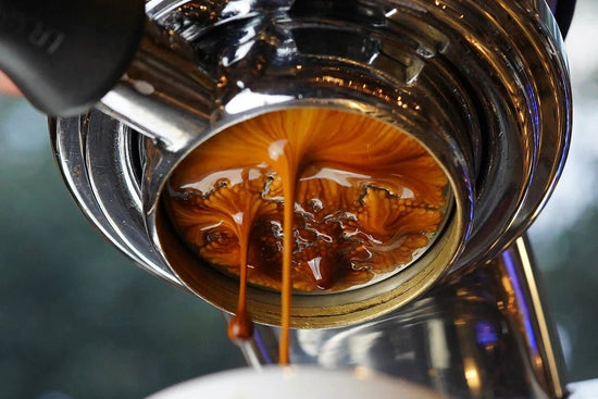 Close up of espresso extraction with crema swirling from the portafilter