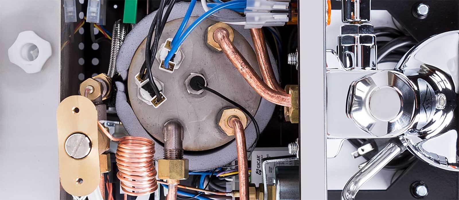 Interior of an espresso machine showing copper tubes and electrical wiring