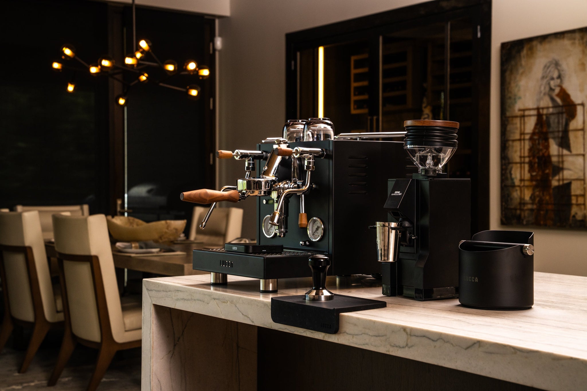 Espresso machine with grinder and glass hopper on a marble counter in a stylish cafe interior.