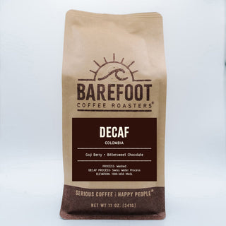 Brown paper bag from Barefoot Coffee Roasters labeled Decaf Colombia.