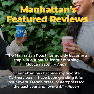 Outdoor cafe scene with two people holding coffee cups and Manhattan's Featured Reviews overlay text.