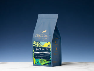 Cafe Kaldi bag upright against a deep blue sky, showcasing the colorful label and Kaldi's branding.