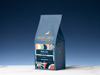 Cafe Malta coffee bag by Kaldi's Coffee placed upright against a deep blue sky backdrop