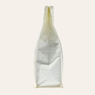 Tall coffee bag with beige wave pattern and subtle printed text on the wrapper.