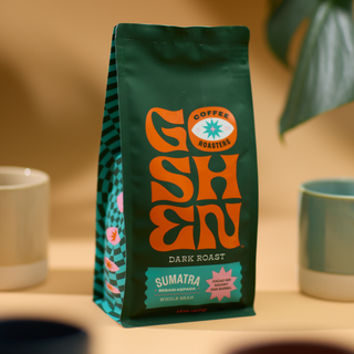 Close-up of Sumatra Bebagi Kepada bag showing a green package with an orange logo and turquoise striped edge