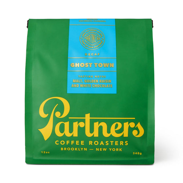 Green Partners Ghost Town Decaf coffee bag with a blue label and yellow branding.