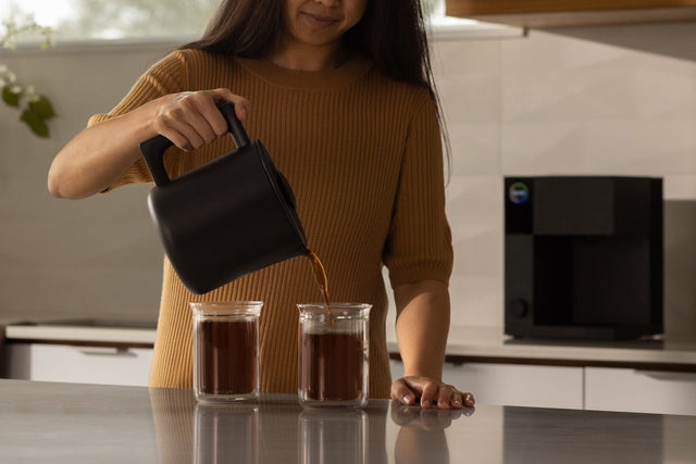 Aiden Precision Coffee Maker, from Clive Coffee, woman pouring coffee, lifestyle