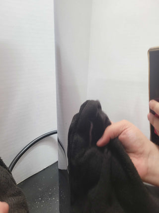 Open box Eureka Atom W 75 coffee grinder shown from the side with a gloved hand holding a phone in reflection