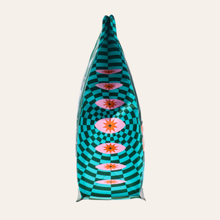 Close up of a teal checkered coffee bag tip against a pale background