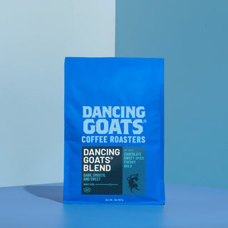Dancing Goats coffee bag standing upright against a two tone blue backdrop