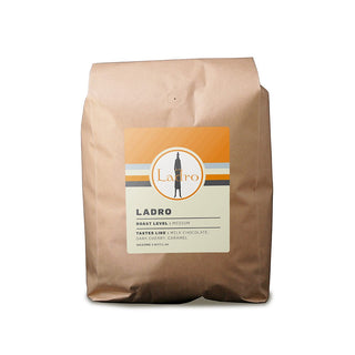 Ladro Espresso Blend bag front view with orange label and striped background.