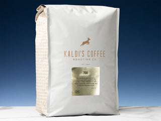 Front view of Kaldi's Coffee 700 bag with logo against a deep blue sky.