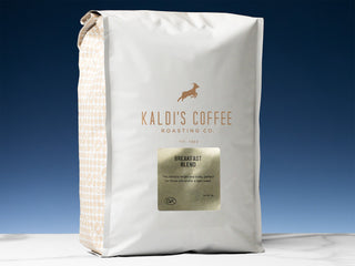 White Kaldi's Breakfast Blend bag with gold label and beige side pattern against a blue sky backdrop