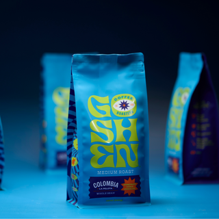 Blue Colombia La Pelota whole bean coffee bag with Goshen Coffee Roasters logo in foreground