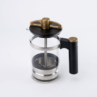 Close up of The BIRD coffee brewer top featuring a bronze lever on a glass chamber.