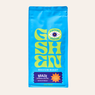 Close up of Goshen Coffee Brazil Fazenda Frutas bag with a lime green logo against a pale background