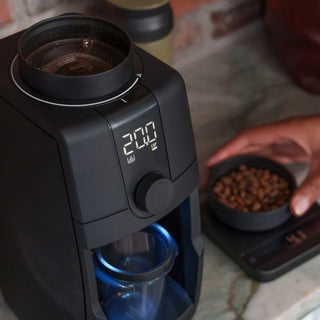 Baratza Encore ESP Pro grinder being loaded with roasted coffee beans at the hopper opening