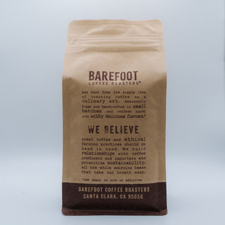 Tan Barefoot Coffee Roasters bag viewed from the front against a pale blue background