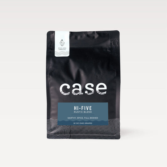 Close up of a black Case Coffee bag with a white Ashland Oregon label and a blue Hi-Five Rustic Blend badge.