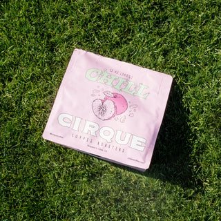 Chill pink coffee bag resting on grass, part of Cirque Coffee Roasters rotating single origin lineup