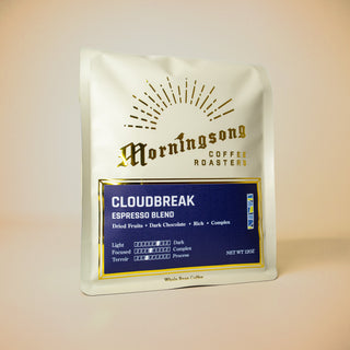 Cloudbreak Espresso coffee bag angled with sunburst graphic and navy blue label