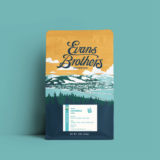 Colombia Nariño coffee bag shown against teal backdrop with landscape artwork and certification label