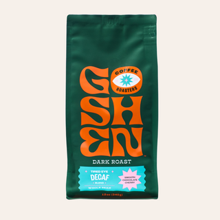Dark green Goshen Coffee bag with a bold orange logo and turquoise label against a light background.