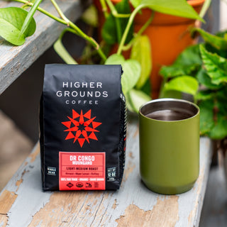 Higher Grounds DR Congo Muungano coffee bag with red star logo on a weathered wood surface
