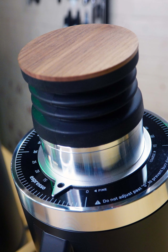 Close up of Turin DF64 Gen 2.5 top with wooden lid and dark collar around the burr chamber.