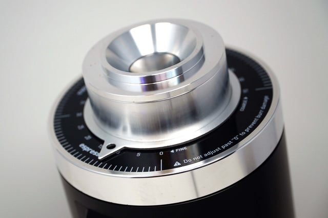 Close up of Turin DF64 Gen 2.5 grinder burr housing with silver metal finish and surrounding measurement dial