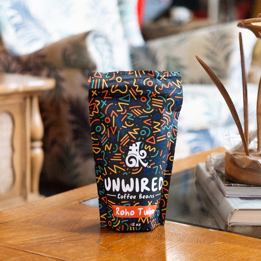 Unwired Coffee Beans bag with colorful abstract pattern and Roho Tulio label on a wooden surface.
